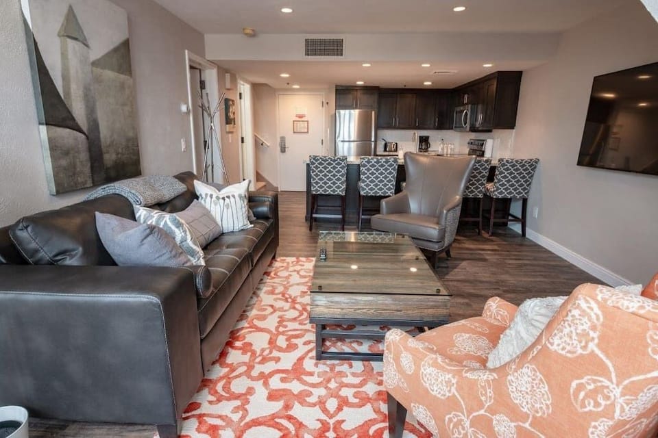 Looking across the living area with the kitchen beyond.  Giant Smart TV w Cable