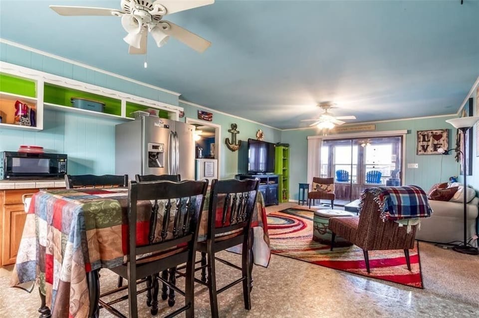 Upstairs kitchen and living room, looking out onto enclosed sun porch and deck