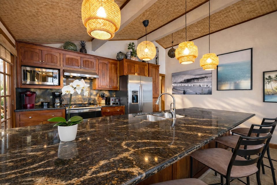 Fully equipped kitchen with bar seating and granite counters, BBQ just outside.
