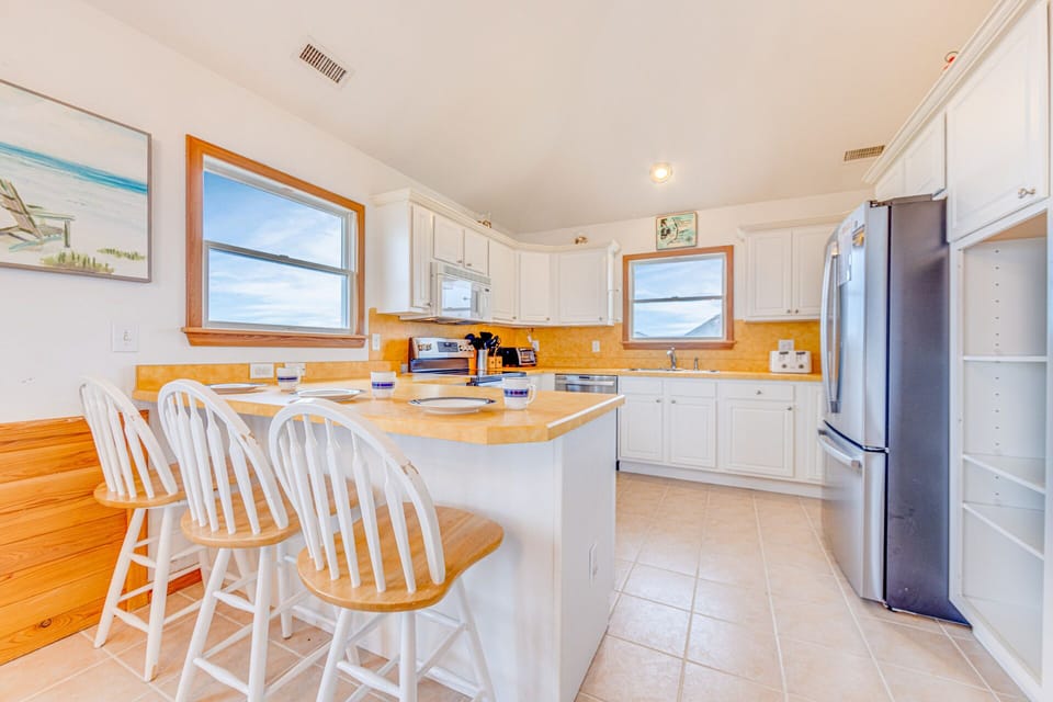 The kitchen comes fully stocked with stainless steel appliances, expansive counter space, and a 3-person breakfast bar.