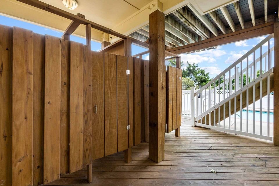Two outdoor showers stand waiting, ready to rinse you off after a sandy day on the beach.