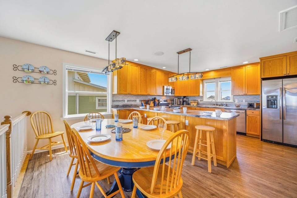 Gather around the spacious dining table where golden light fills the room, or perch at the breakfast bar while you whip up your favorite meals in the fully-equipped kitchen with modern stainless appliances.