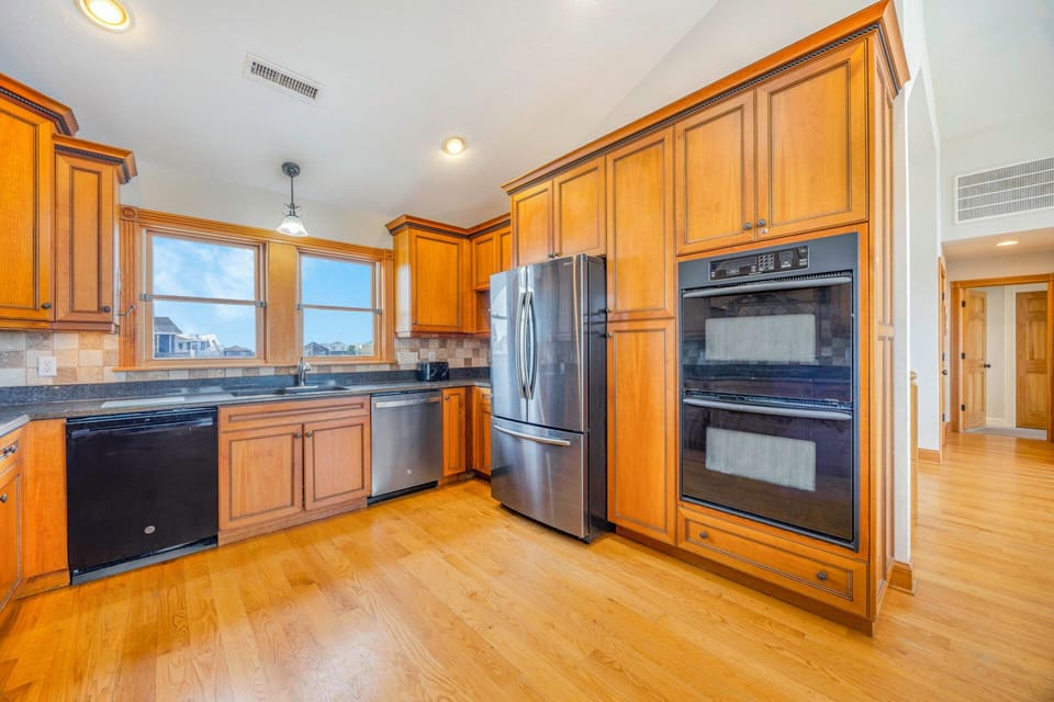 Cook your favorite meals in this fully equipped kitchen with stainless steel appliances, warm wood cabinets, and granite countertops.