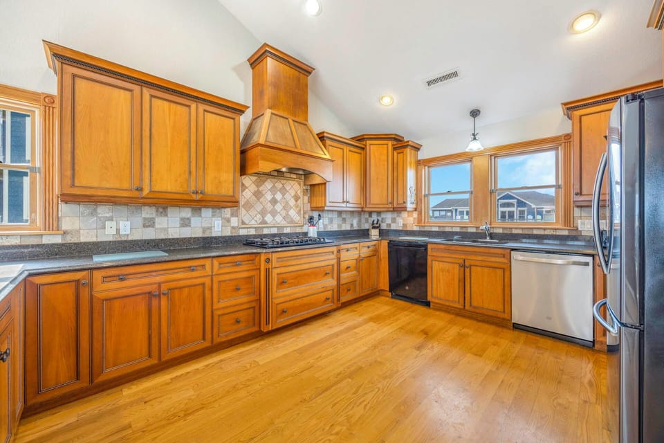 Your spacious kitchen awaits with warm wood cabinetry, granite counters, and stainless steel appliances for memorable meal preparations.