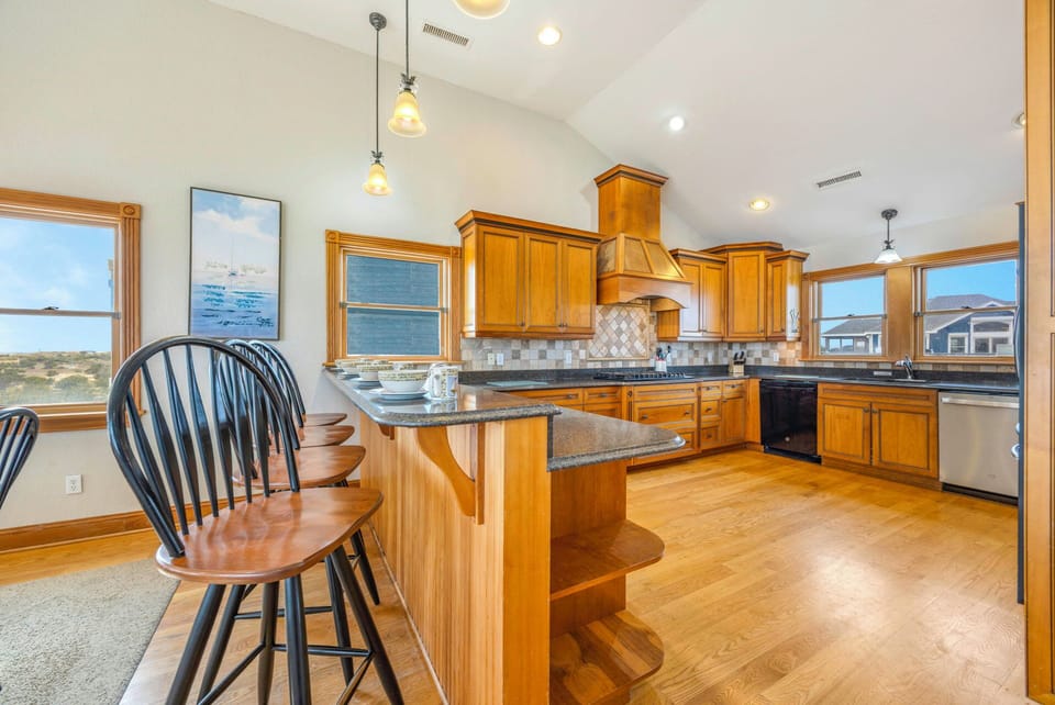 Your spacious kitchen features granite counters, custom cabinetry, and breakfast bar seating for memorable meal prep and morning coffee.