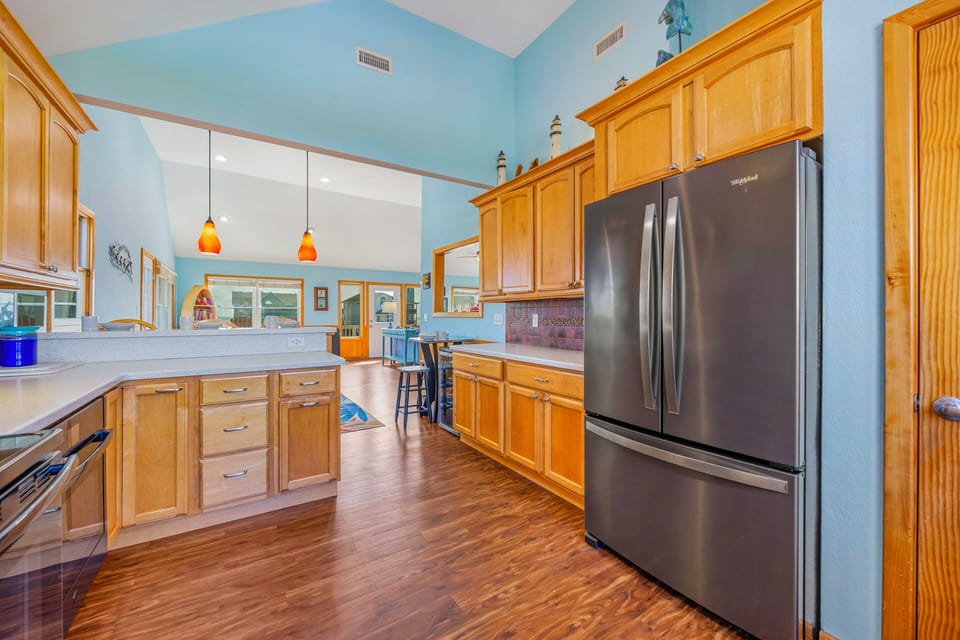 You'll love preparing meals in this spacious kitchen featuring warm wood cabinets, modern stainless appliances, and abundant counter space for culinary adventures.