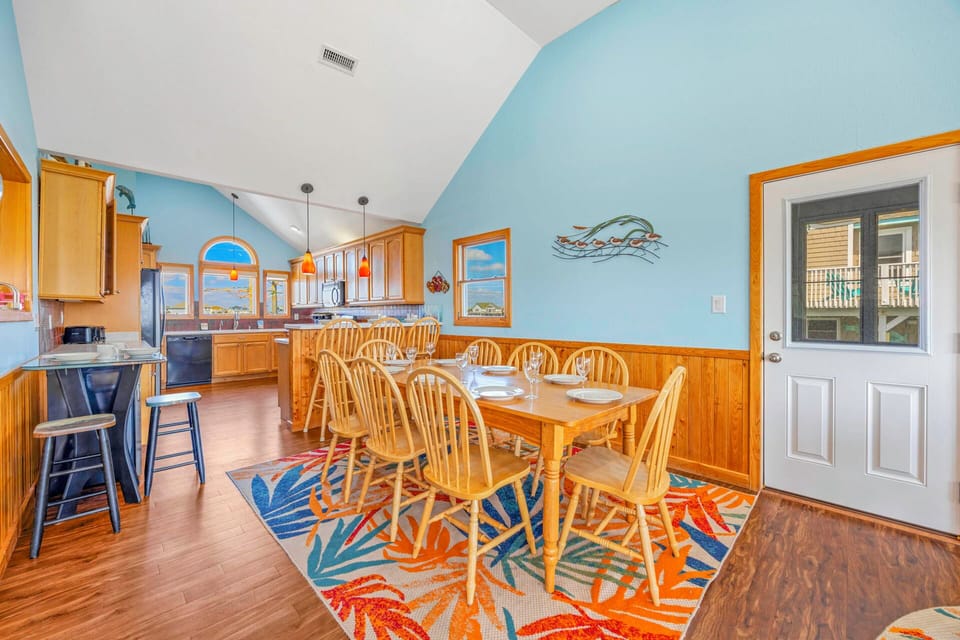 Gather around this spacious dining table where your group can share meals together in this bright, open kitchen.
