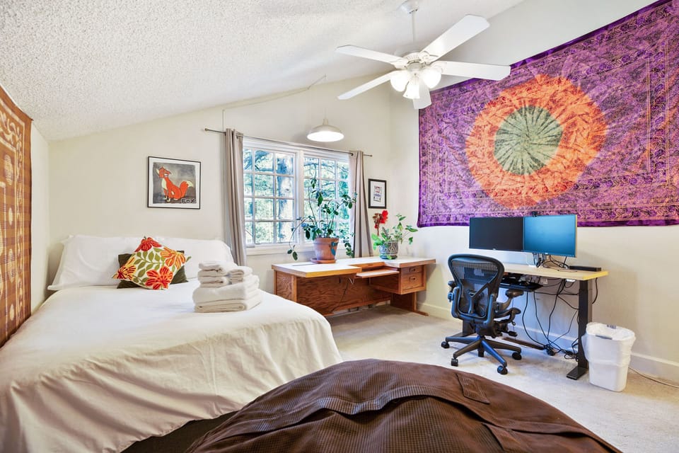 Guest room with full size bed and office setup.