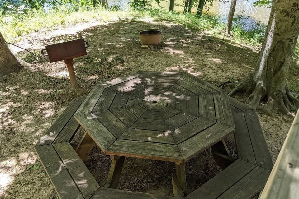 View from the back porch of the outdoor grill, fire pit and picnic table overlooking the lake. 