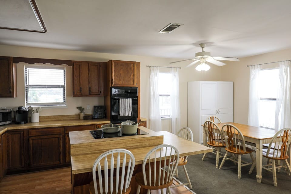 Prepare your favorite meals in a welcoming open kitchen that flows right into the dining area—perfect for gathering everyone together at the spacious farmhouse-style table after a day of adventure.