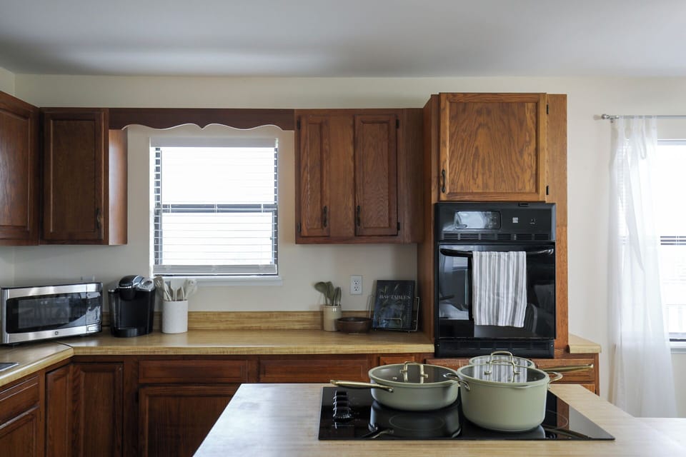 Your spacious kitchen invites culinary creativity, featuring wood cabinetry, modern appliances, and ample counter space for preparing delicious vacation meals together.