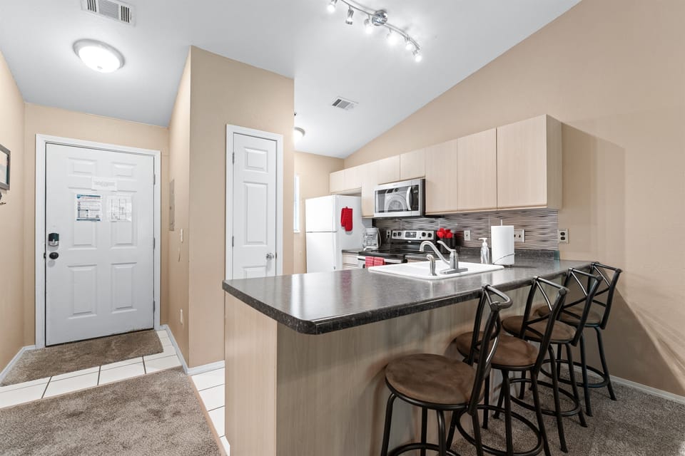 The entry opens into a bright, easy layout with bar seating ready for a quick breakfast or evening drink.