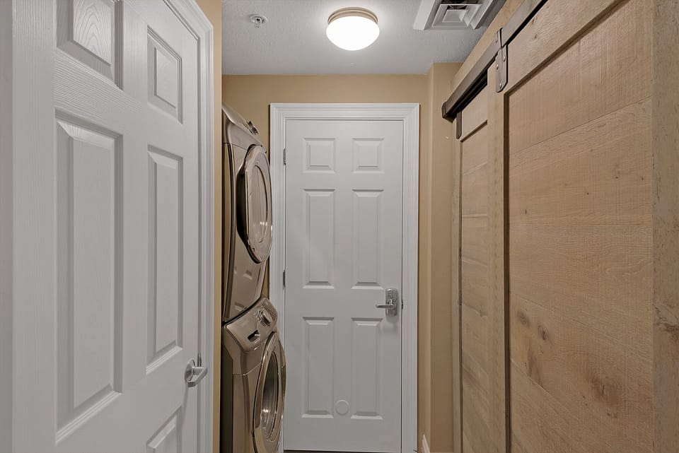 Laundry room with brand new full sized front load washer and dryer