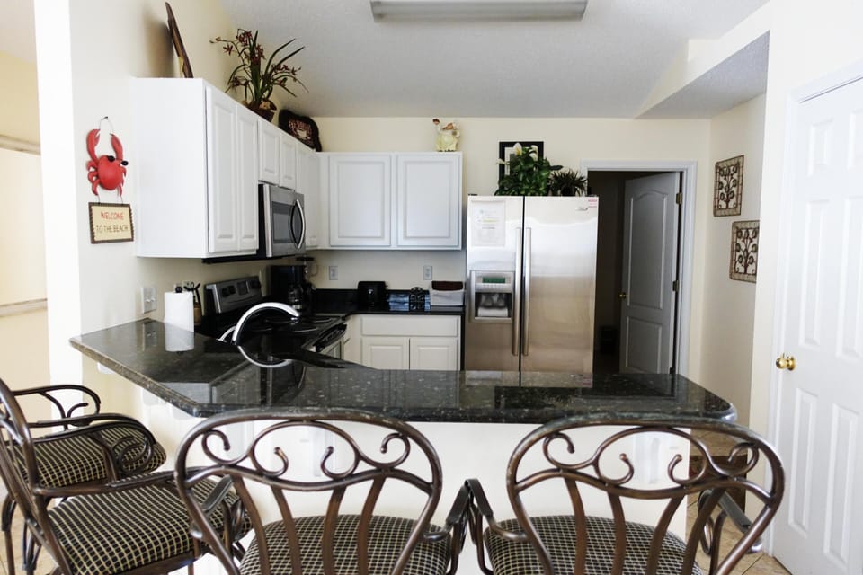 Spacious fully equipped kitchen with stainless steel appliances; bar seats four
