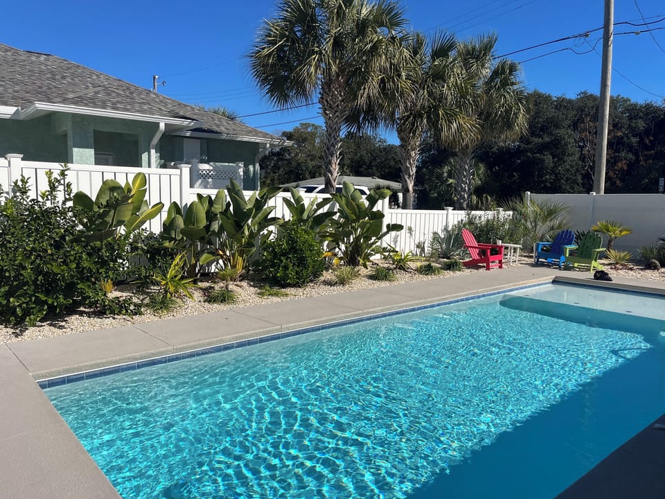 Private pool features a sundeck with jets, 5.5ft depth and lush tropical plants.
