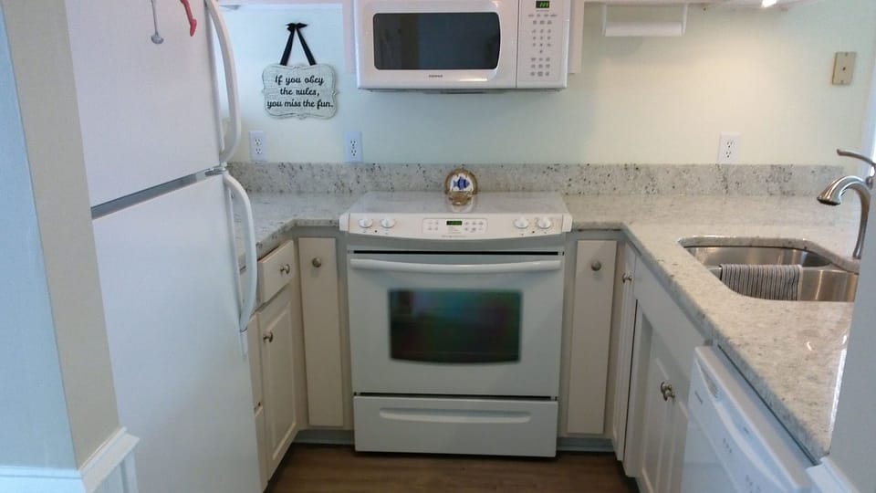 fully stocked kitchen with granite counter tops and dishwasher