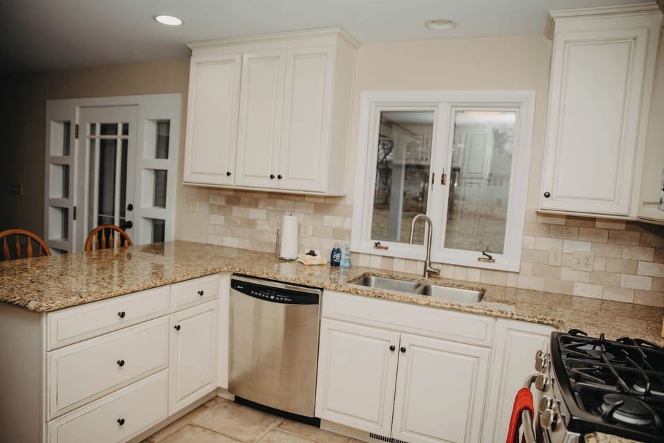 Kitchen showing window overlooking patio and glass doors to patio