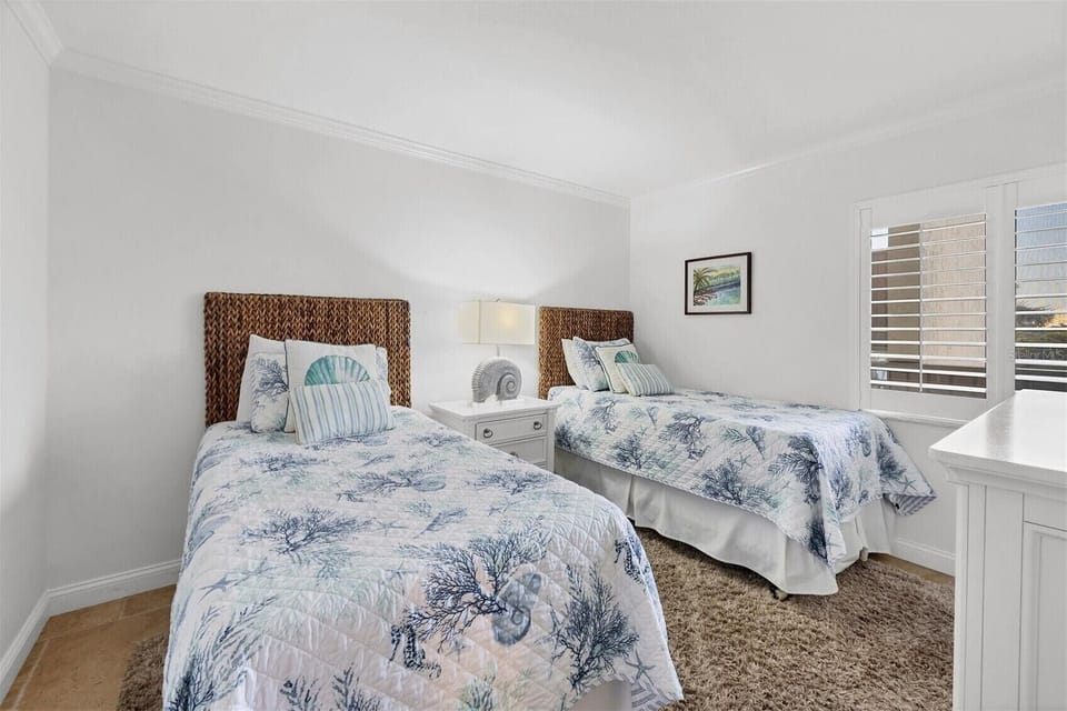 Your coastal twin bedroom features woven headboards and ocean-themed bedding, creating a serene seaside retreat for restful nights.