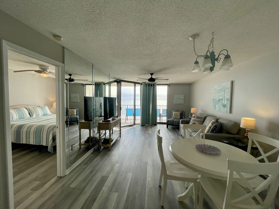 Living Room, Hardwood, TV, Mirror, Ceiling Fan, Table, Couch, Bed Balcony, Art.