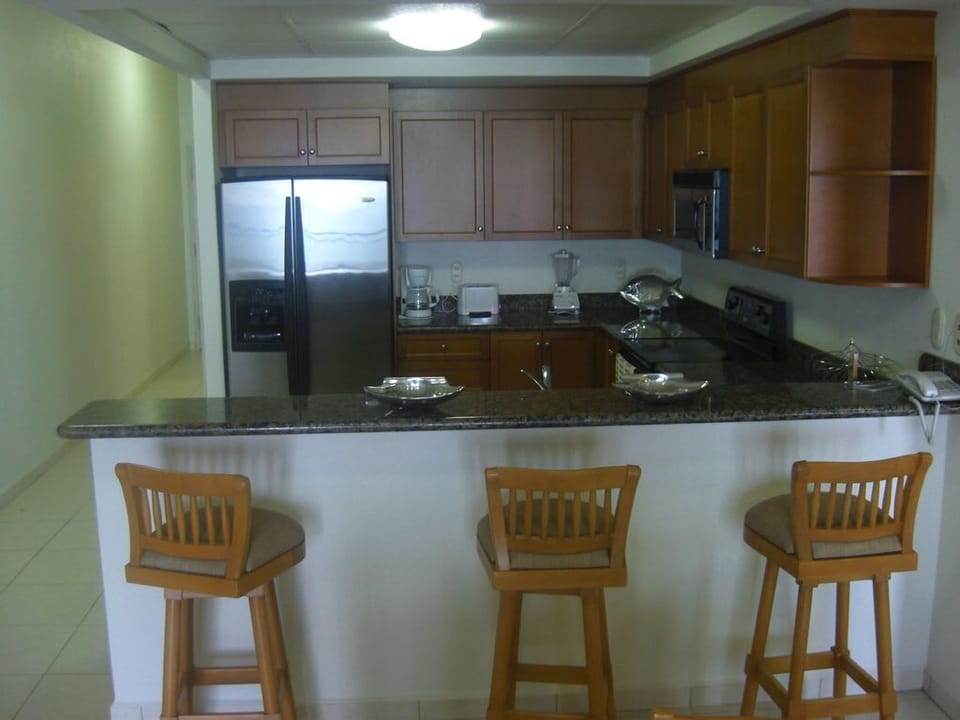 bar stools and well equipped kithcne
