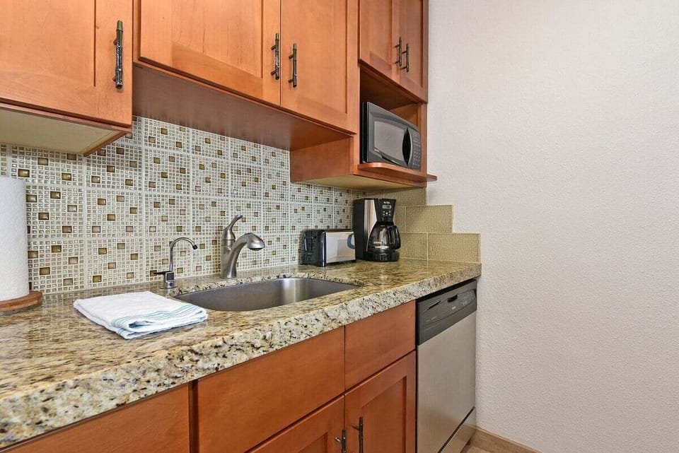 Clean, functional kitchen with full‑size appliances and a stylish tile backsplash