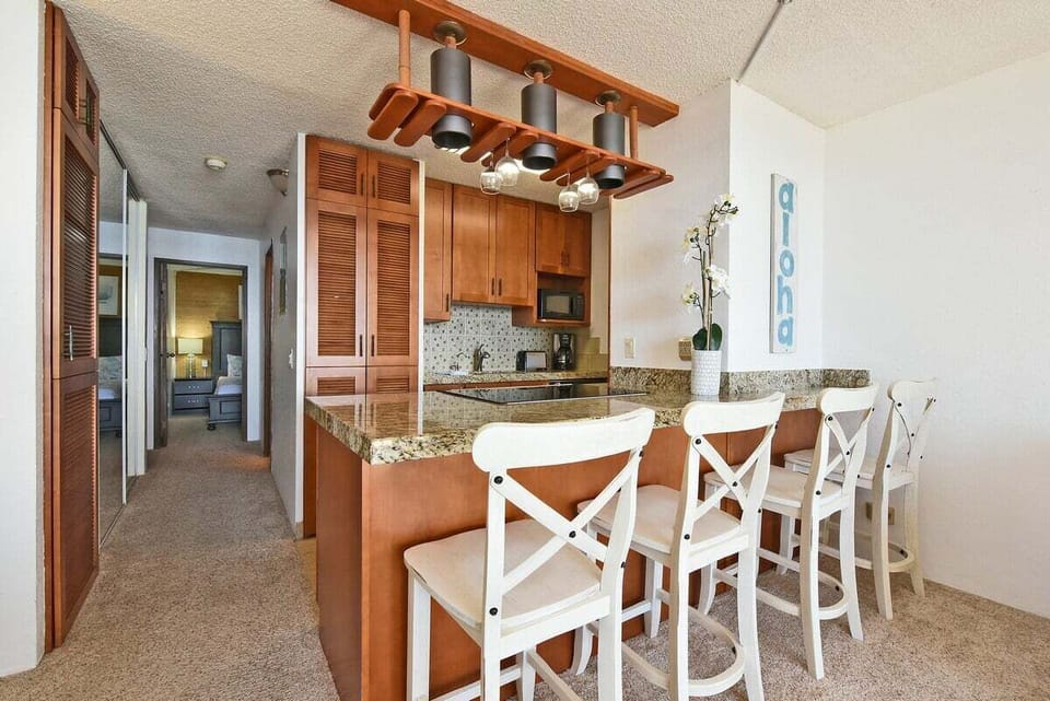 A functional dining‑in bar space with granite counters and warm cabinetry