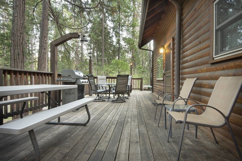 Side view of cabin, refinished deck with beautiful outdoor lighting and gas grill BBQ.