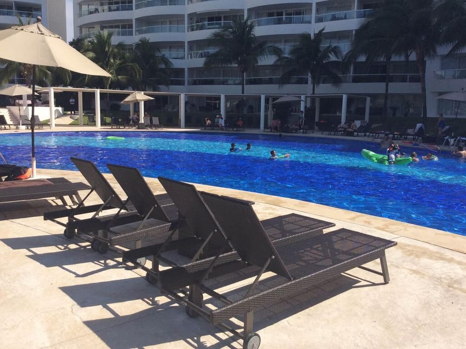 lots of lounge chairs around the pool