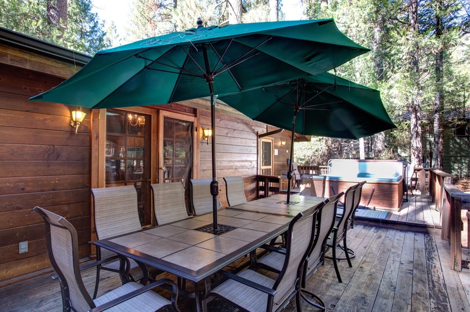 Back deck with umbrella picnic tables and hot tub
