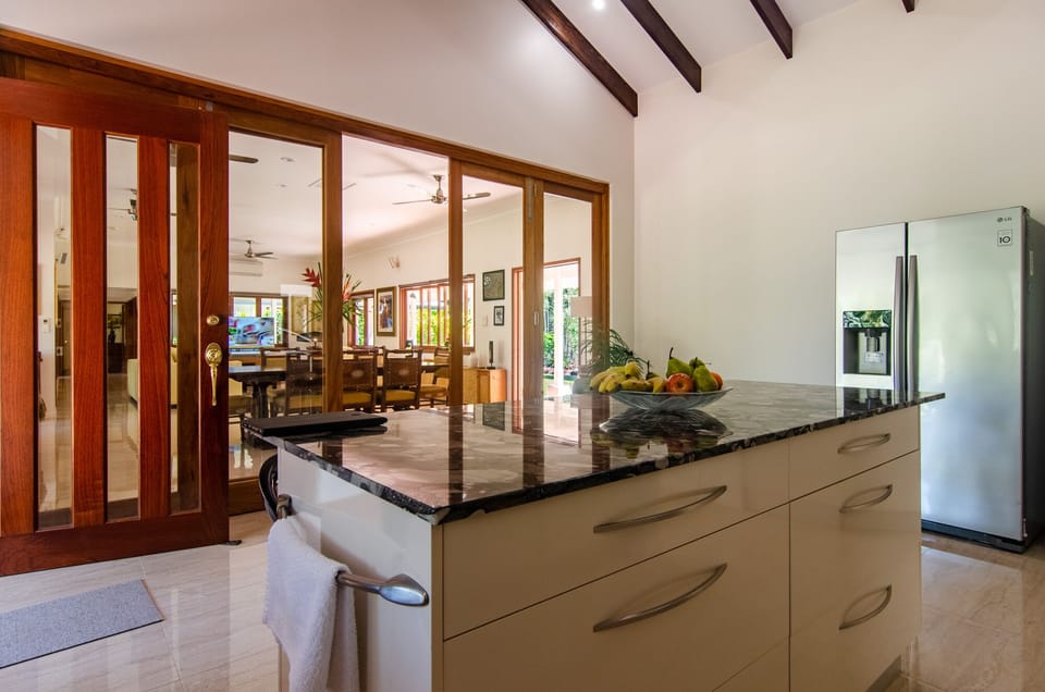 kitchen  is divided by h bifolds,has exposed beam ceiling , island breakfast bar