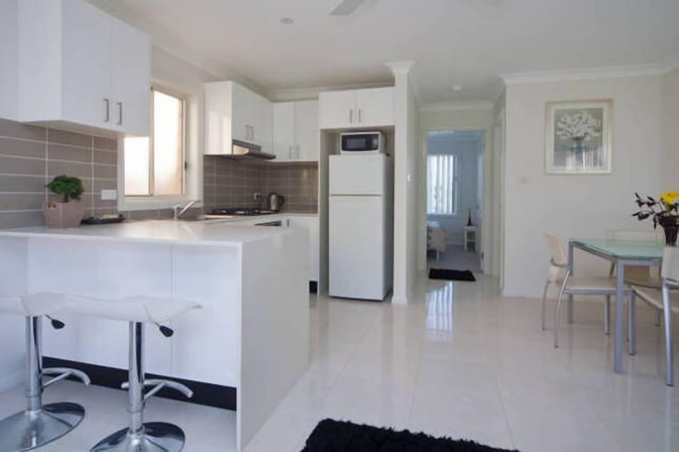 Spacious, tiled kitchen and dining area with fridge and microwave