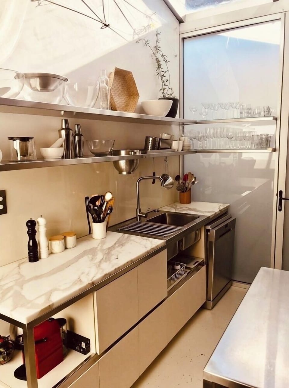 light filled  kitchen with marble 
benches and stainless steel cabinetry