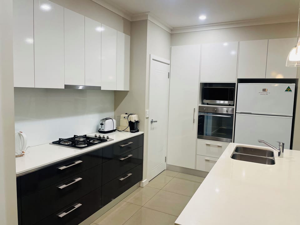 Kitchen has gas cooktop, microwave, electric oven and lots of pots, cutlery etc