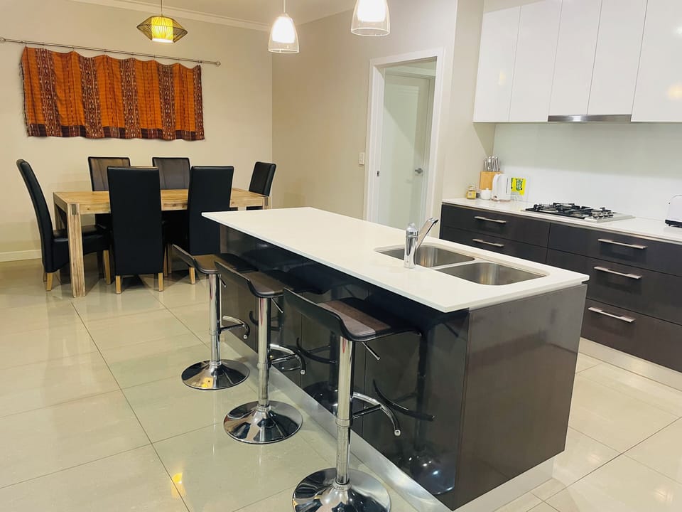 Kitchen with dishwasher and ISLAND bench close to dining table and living room