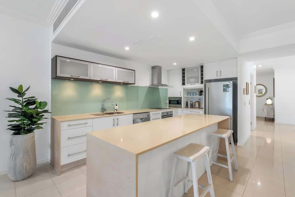 Gather around the generous kitchen island—ideal for casual bites, morning coffee, or sharing stories while you cook.
