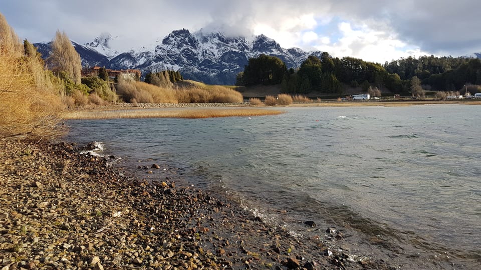 Vista al hotel Llao Llao y montañas desde la costa