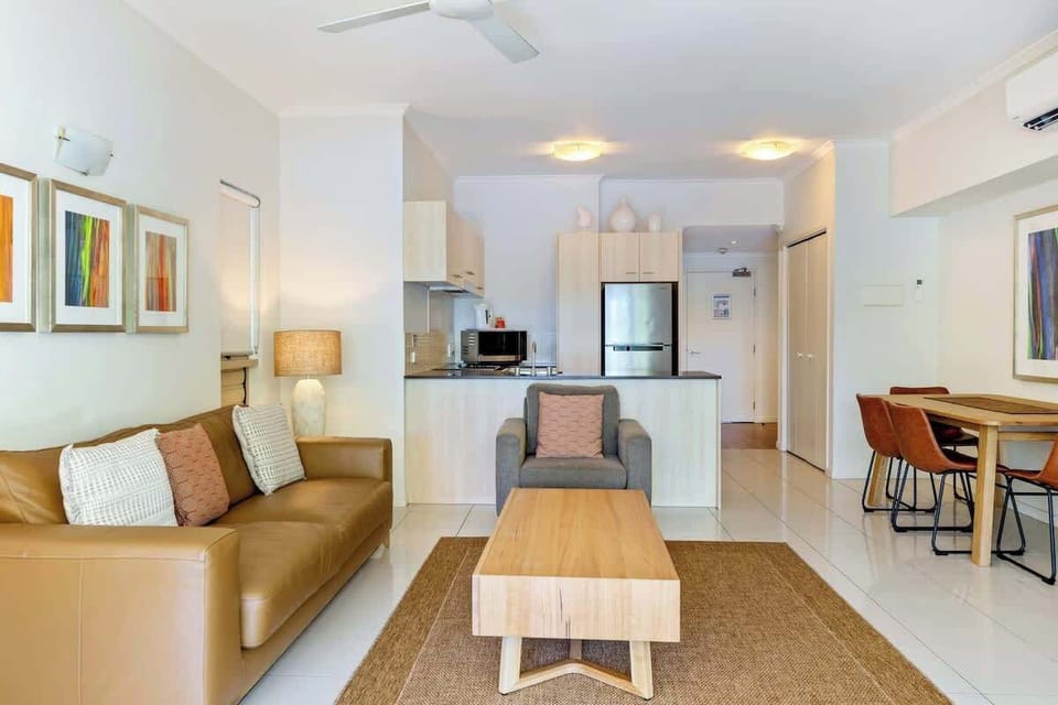 Air-conditioned open plan living is set with two comfortable sofas to sink into after a day at the beach.