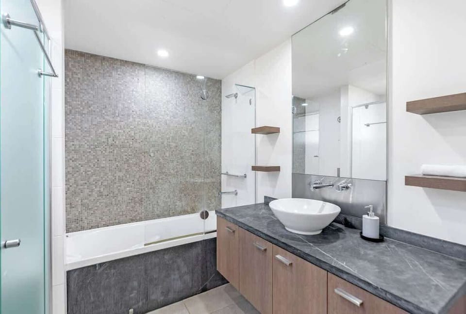 Indulge in relaxation with a bath in the main bathroom, complete with towels, toiletries, and a spacious vanity.
