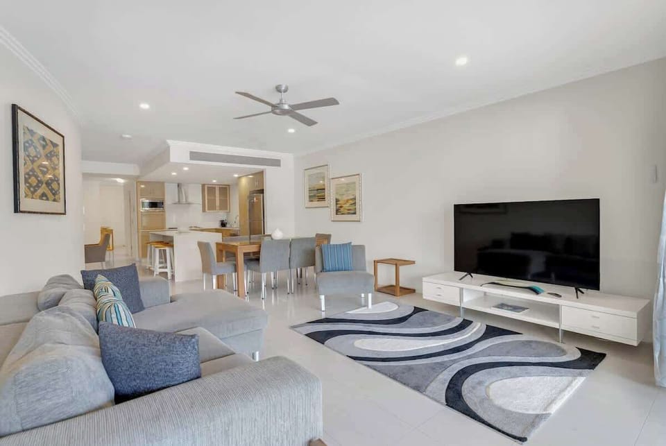 Kick back in the living room, featuring an L-shaped lounge fronting a central Smart TV.