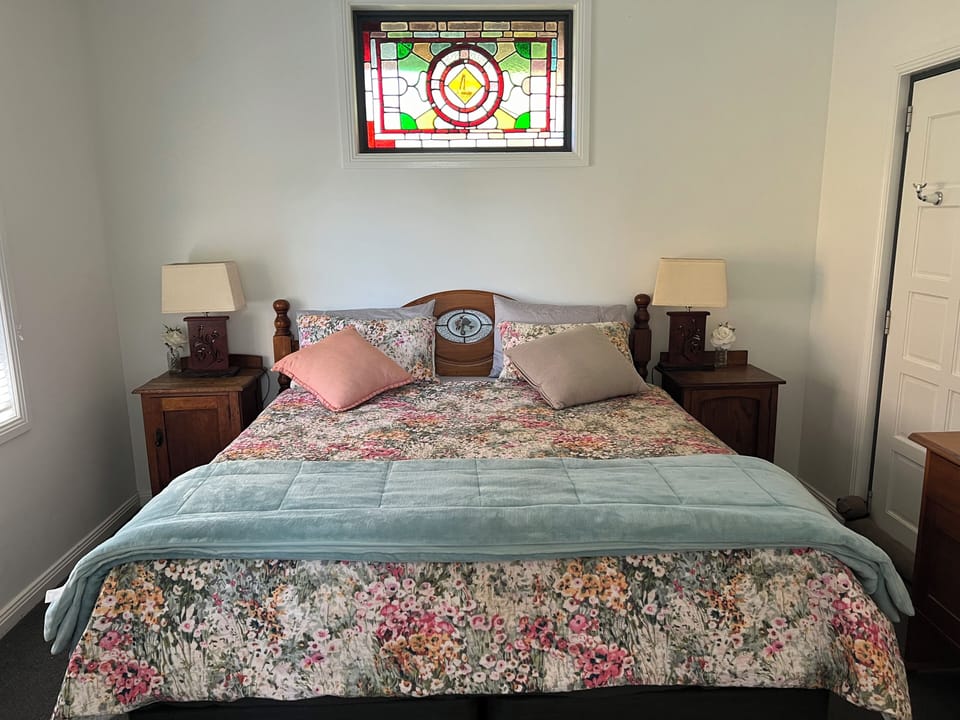 King bed with beautiful wood furniture and stained glass