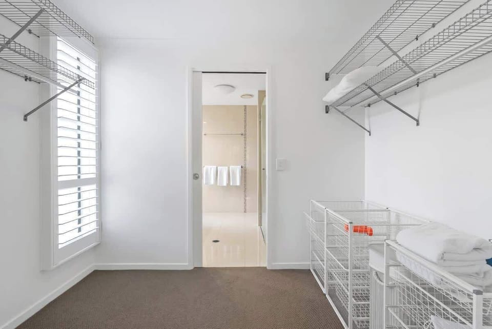The primary bedroom features a walk-in wardrobe with plenty of storage for your belongings and luggage.