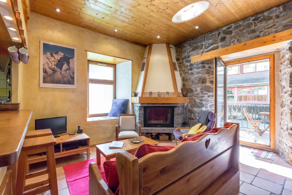 Living room with fireplace and access to the riverside balcony.
