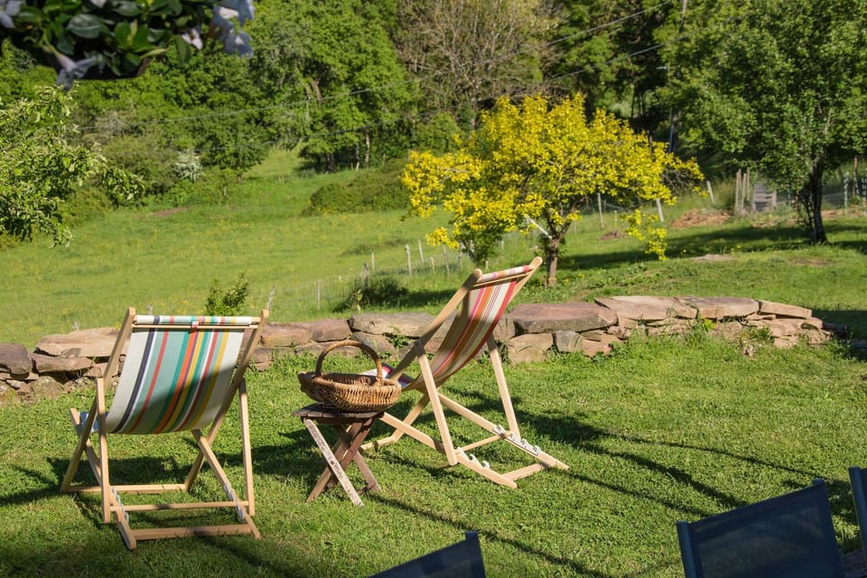 Jardin du gîte Grande Ourse à Noailhac avec chaises longues et vue panoramique sur la campagne