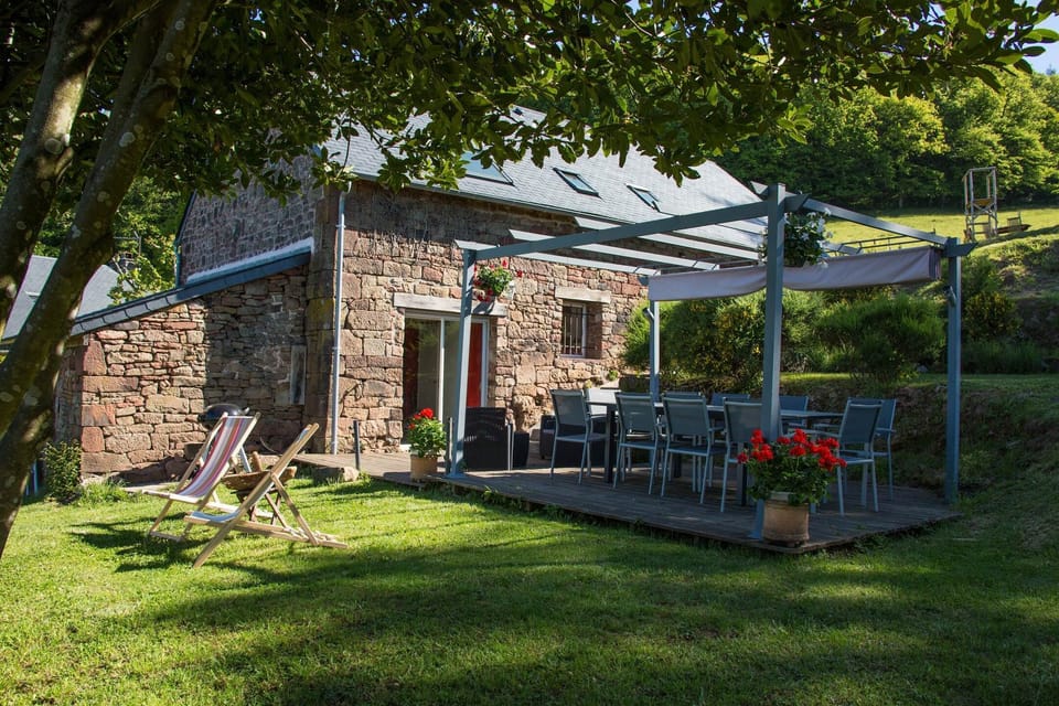 Terrasse couverte du gîte Grande Ourse à Noailhac en Corrèze avec espace repas ouvert sur le jardin