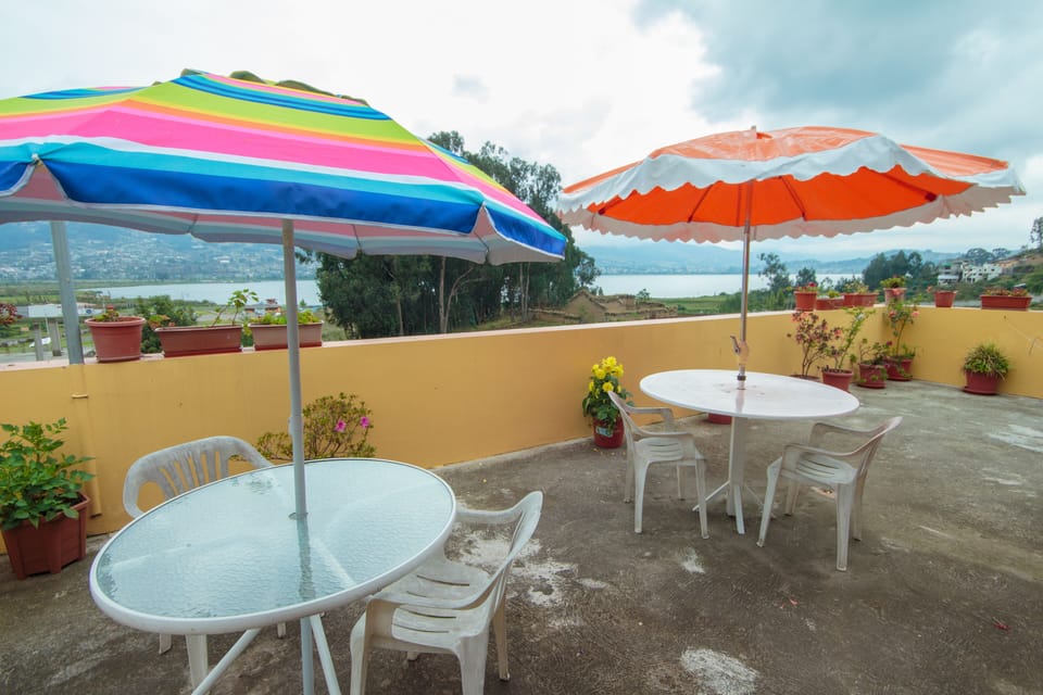 Tables with umbrellas at the terrace with lake and MOUNTAINS views