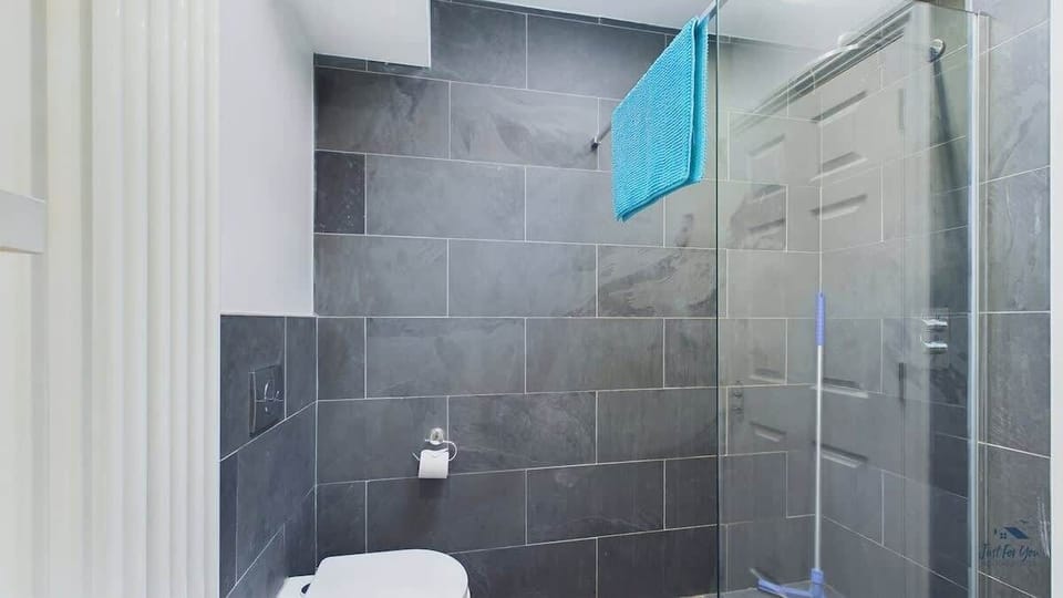 Ground-floor accessible wet room with rainfall shower, WC and laundry facilities.

