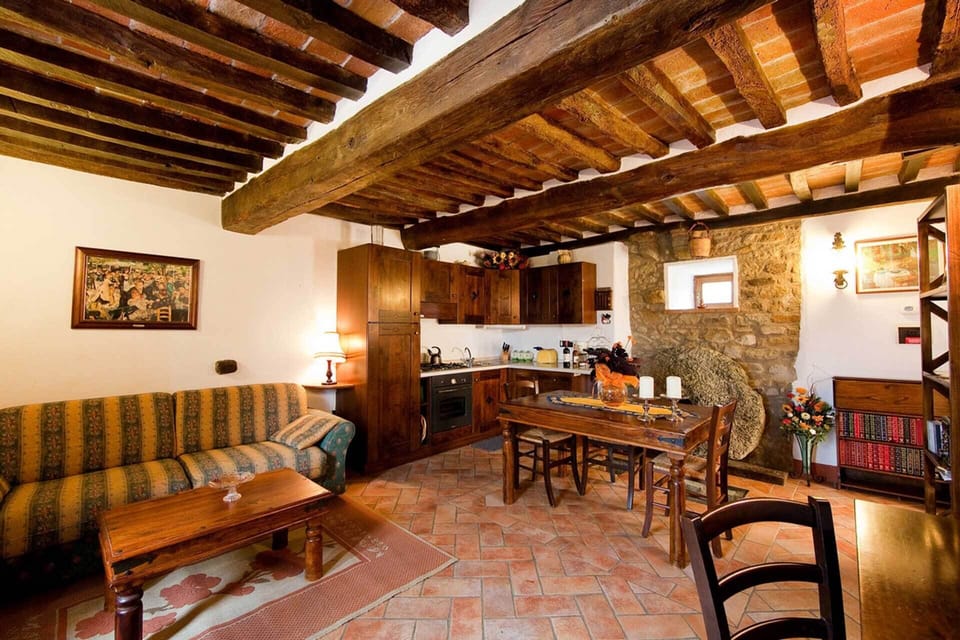 Kitchen living room has dining table, desk and a large sofa-bed