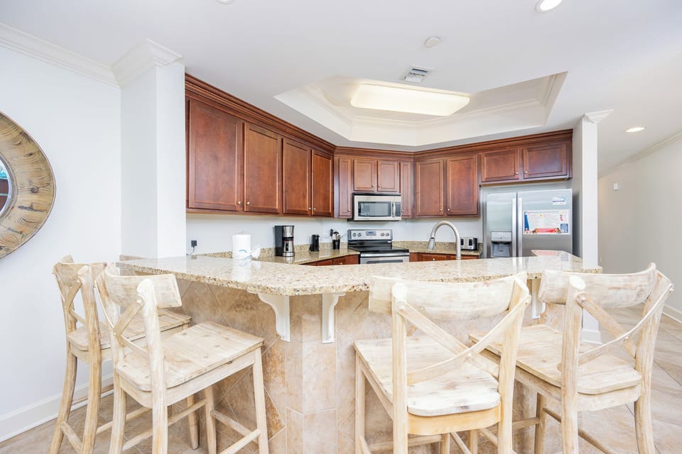 This kitchen features rich wooden cabinetry, stainless appliances, and a granite countertop, perfect for casual dining