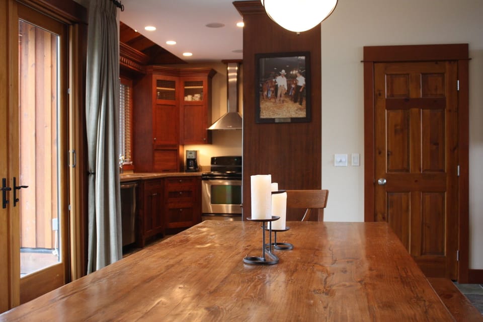 Dining room table view into fully equipped kitchen and pantry