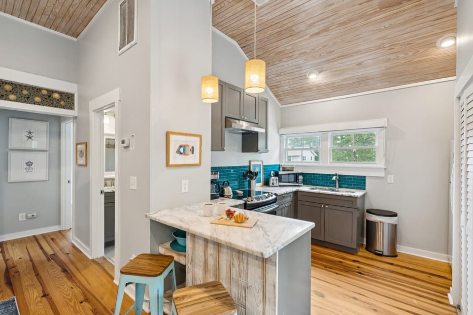 A small breakfast bar separates the kitchen and living room, with seating for 2.